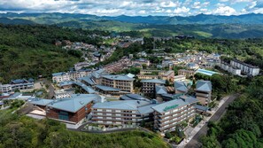 Zona residencial com edifícios altos, uma estrada e montanhas ao fundo.