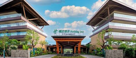 A modern building with a covered entrance and a sign for the Holiday Inn.