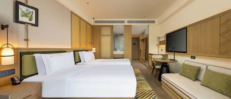 Una habitación de hotel con una cama grande, un escritorio, un sofá y un televisor.