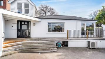 A modern two-story house with a front porch, a garage, and a small deck.