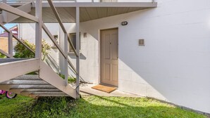 Un edificio blanco con una escalera que lleva a una puerta marcada con el número 2.
