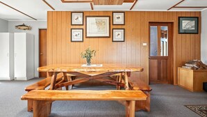 Ein Holzespeisesaal mit Bänken in einem Raum mit Holzwänden und gerahmten Bildern.