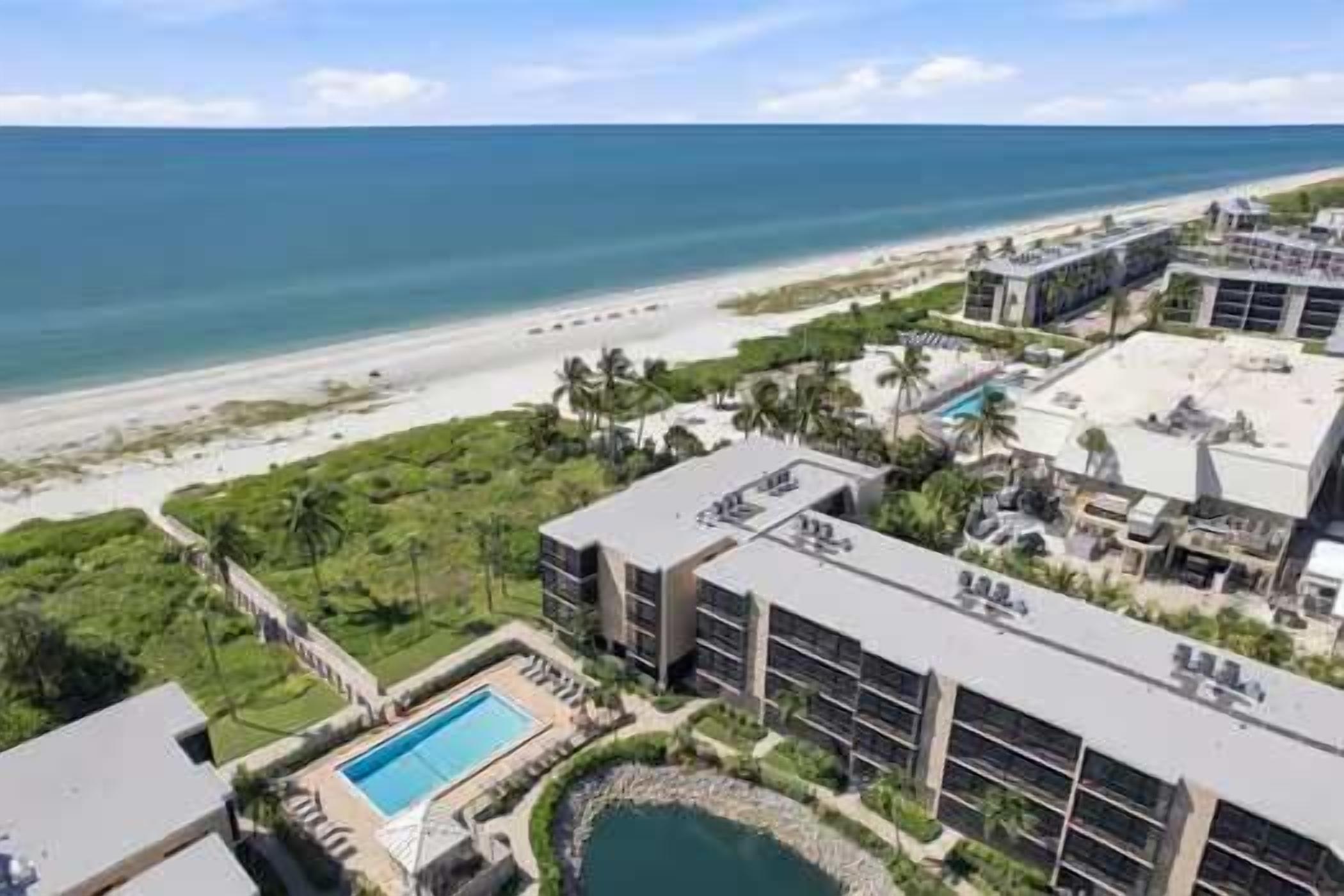 A resort with a pool, beachfront view, and multiple buildings.