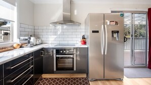 Una cocina moderna con electrodomésticos de acero inoxidable, horno empotrado y un amplio ventanal que proporciona luz natural.