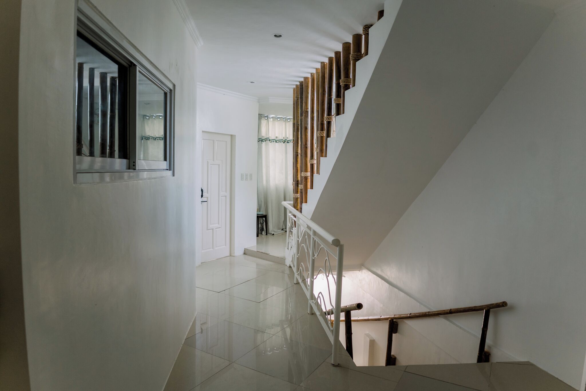 A staircase with a wooden handrail and metal balusters, leading to an upper floor.