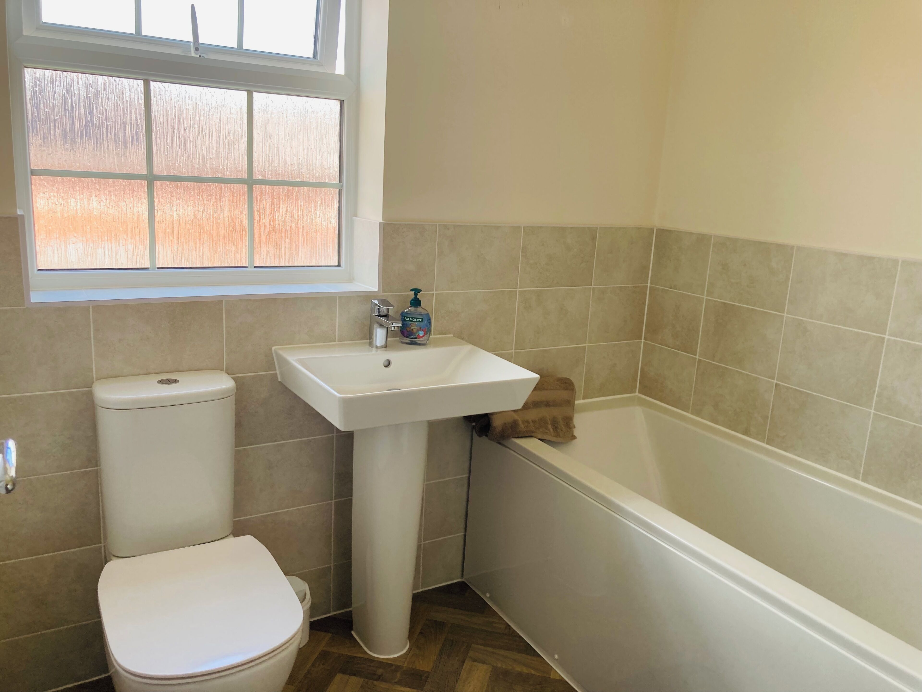A bathroom with a toilet, sink, and bathtub.