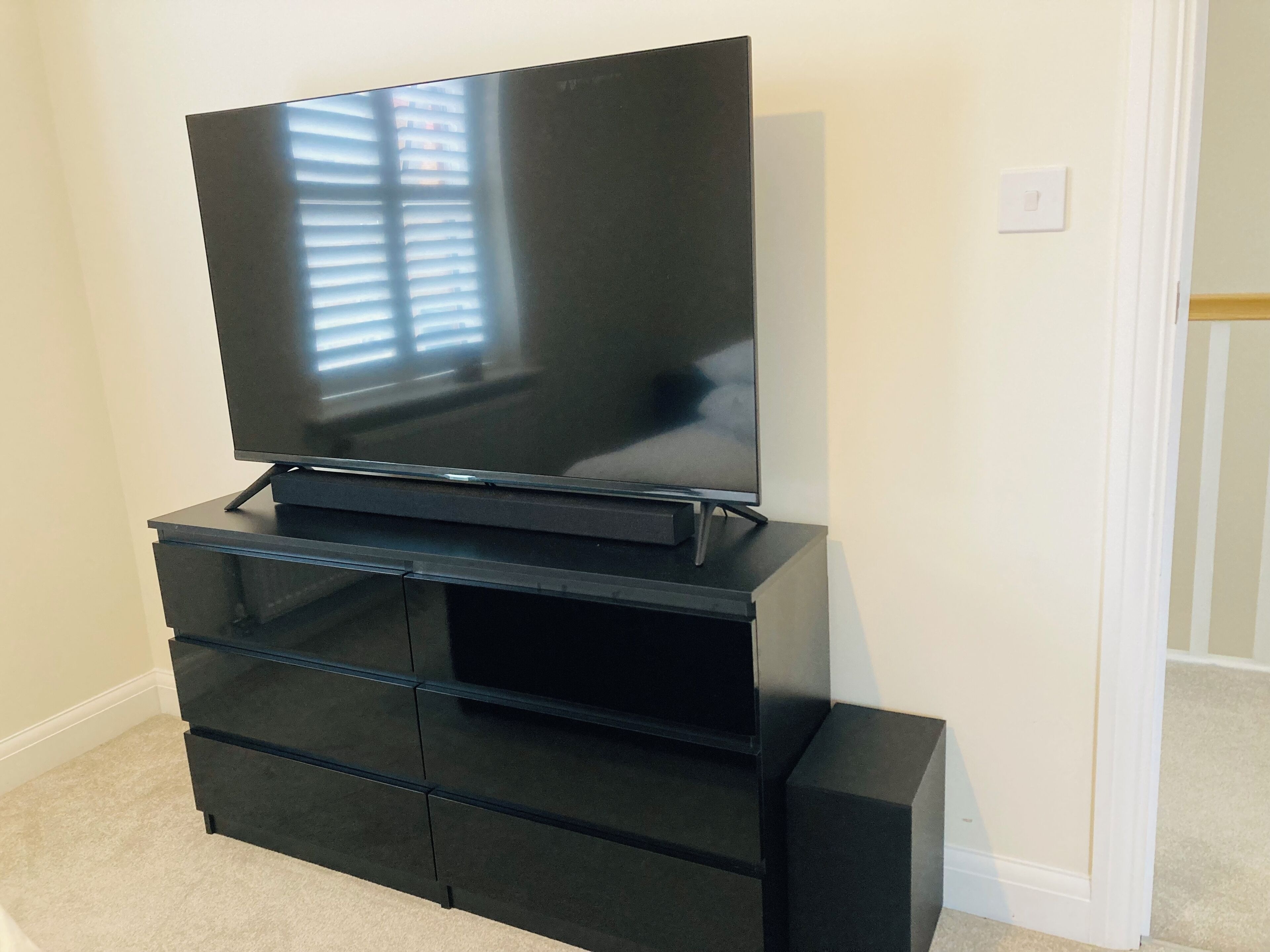 A black entertainment center with a flat-screen TV mounted on top.