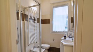 A bathroom with a glass-enclosed shower, a toilet, a bidet, and a sink. - Studio With Balcony in Bovisa Milan (Milan)