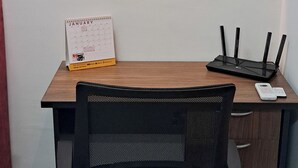 A desk with a calendar, a framed picture, and a router. - The Red Room @ Alanis Residence Sepang, KLIA1 and KLIA2 (Sepang)