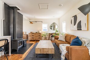 A cozy living room with a fireplace, wooden furniture, and a large mirror.