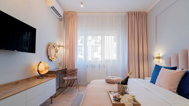 Une chambre d’hôtel comprenant un lit, un bureau avec un globe terrestre, une chaise, une télévision et un mini-bar.