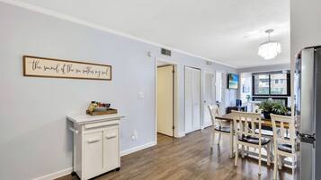 A kitchen with a dining area, a white cabinet, and a ceiling light fixture.