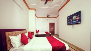 A hotel room with a large bed, a TV mounted on the wall, and a ceiling fan. - Balada Castles Hotel & Resort (Dera Bassi)