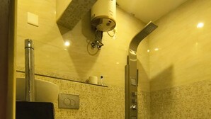 A bathroom with a toilet, bidet, and a shower.
