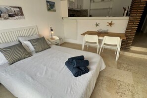 A hotel room with a bed, a desk, and a chair.