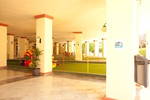 A covered outdoor area with a play area, a Wi-Fi sign, and a trash bin.