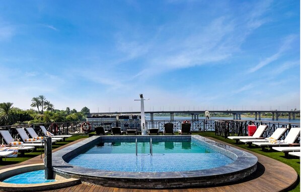 Relax by the pool with a view of the bridge and palm trees.