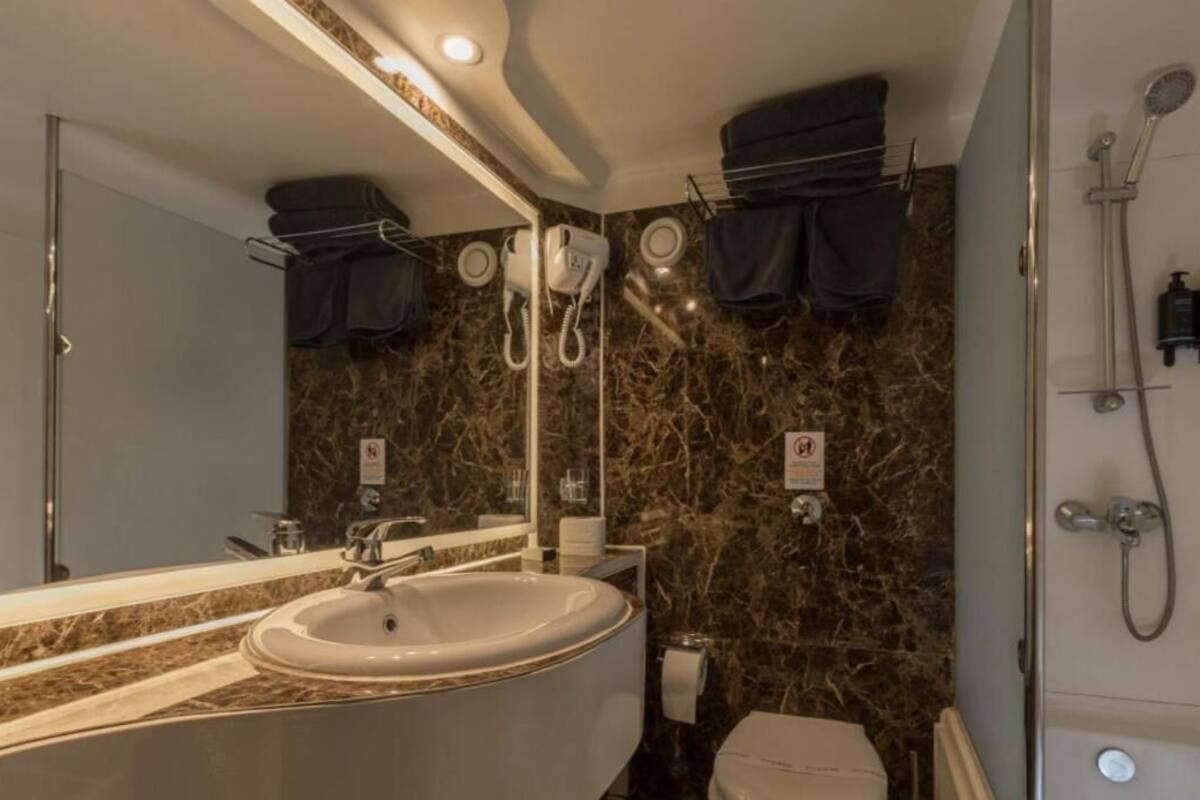 Een badkamer met een grote wastafel, spiegel en douche.