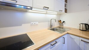 A modern kitchen with white cabinets, stainless steel appliances, and a wooden countertop. - Nice apartment for 4 people with WIFI and TV (Jablonec Nad Nisou)