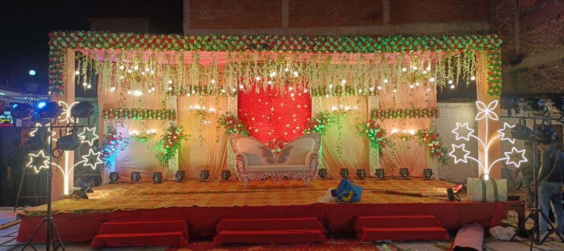 A stage with a red backdrop, a sofa, and decorative lights.