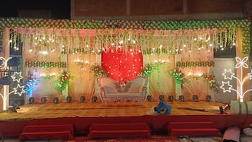 A stage with a red backdrop, a sofa, and decorative lights.