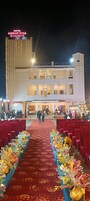 Un hotel con alfombra roja que conduce a la recepción, varios pisos y una fachada bien iluminada.