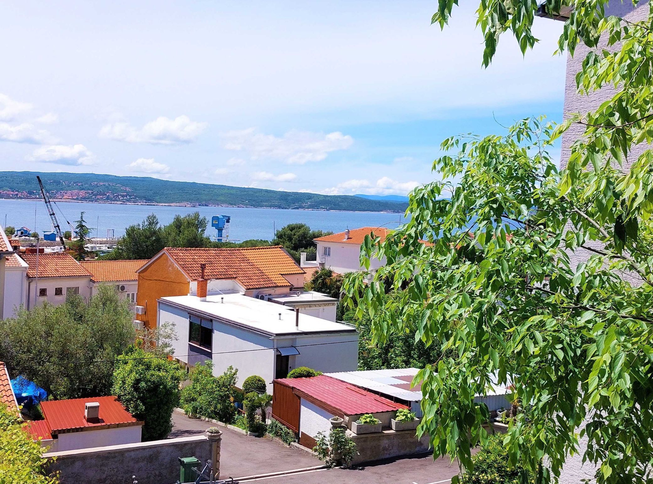 A coastal town with buildings, a clear sky, and a view of the sea.