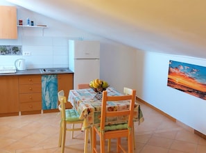Enjoy meals in the kitchen with a stove, sink, and refrigerator, and dine at the adjacent table with comfortable seating.