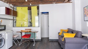 A compact living space with a kitchen, a dining area, and a seating area. - Le Marais St.Paul Mobility lease apartment  (Paris)