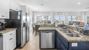 A modern kitchen with granite countertops, stainless steel appliances, and a view of the surrounding buildings. - Heated Pool Hot Tub Gulf View Elevator, Top (Gulf Shores)