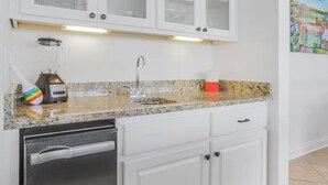 A kitchen with white cabinets, a stainless steel dishwasher, and a granite countertop. - Heated Pool Hot Tub Gulf View Elevator, Top (Gulf Shores)