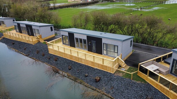 A modern building with a flat roof, large windows, and a wooden deck. - Malton 2-bed Lodge, Sleeps 4, Pet Friendly (Malton)