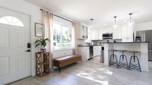 A modern kitchen with white cabinets, a built-in microwave, and a stainless steel refrigerator. - *NEW* Riverside Retreat w/ Pool (Jupiter)