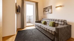 A modern living room with a grey sofa, a black rug, a sliding glass door, and a framed picture on the wall. - Superior Chalet With Finnish Sauna (Hermagor-Pressegger See)