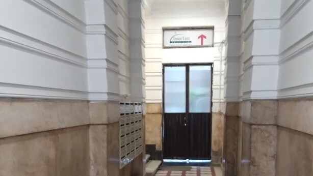 A hallway with patterned flooring, a door with a sign above it, and a trash bin to the left. - Comfortable apartment in delightful Beograd with WiFi, AC (Beograd)
