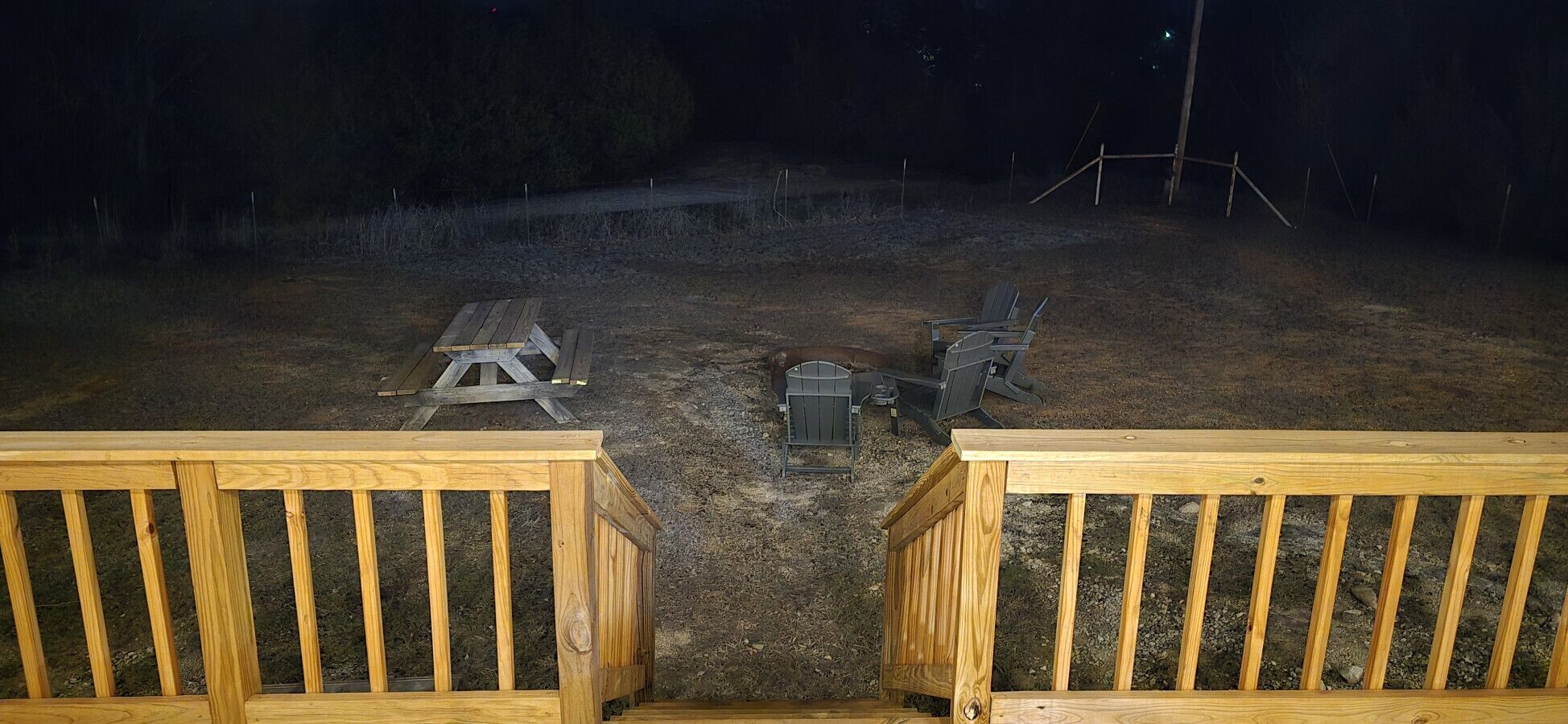 Una terraza de madera con una parrilla metálica y una mesa para asar.
