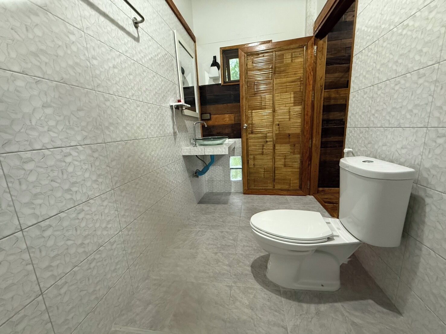 Une salle de bain avec des toilettes, un lavabo et un miroir.