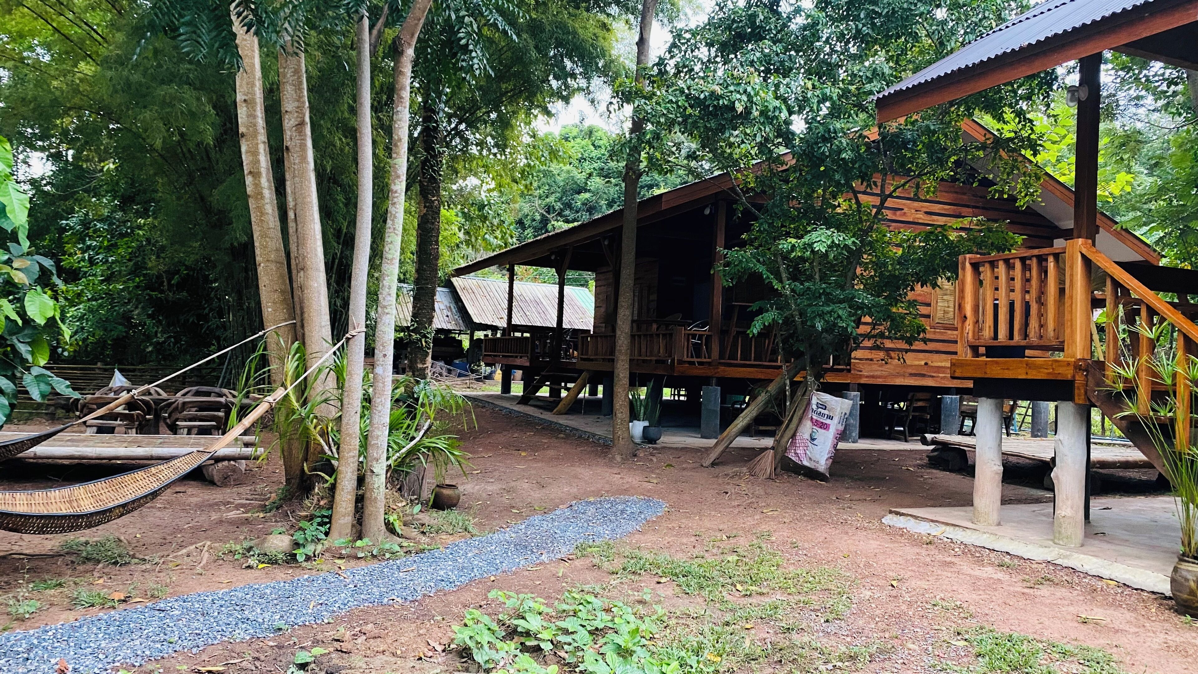 Une structure rustique en bois, dotée d’un porche et d’un hamac suspendu.