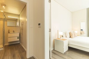 A hotel room with a bed, bedside table, and a mirror. - Coralina Loft by Atlantic Holiday (Funchal)