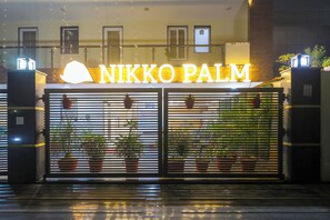 A hotel entrance with a large illuminated sign reading "NIKKO PALM".