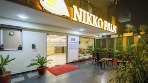 A hotel entrance with a sign reading "NIKKO PALM". - Nikko Palm Near Huda City Centre (Gurugram)