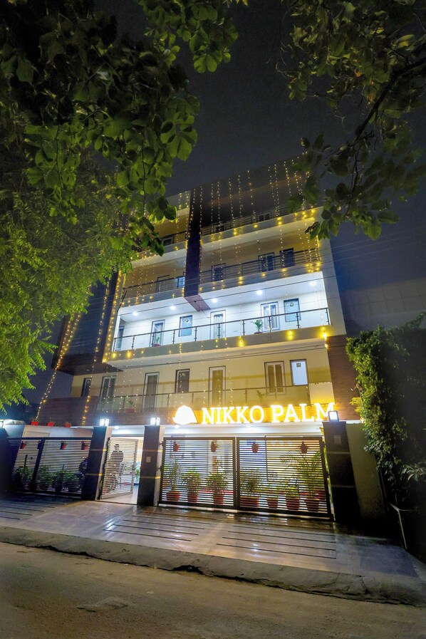 A multi-story building with a sign reading "Nikko Palm."