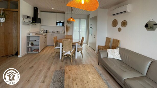 A modern living space with a kitchen, dining area, and a sofa. - Modern house with AC, garden and parking, near Noirmoutier beach (Barbâtre)