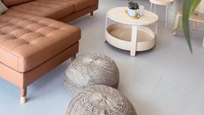 Una sala de estar moderna con un sofá modular, una mesa de centro redonda y otomanas.
