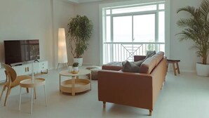 Una sala de estar moderna con un sofá, sillas, un televisor y plantas en macetas.