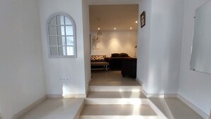 Una escalera conduce a una sala de estar con un sofá y una lámpara.