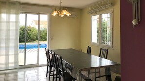 A dining area with a table and chairs, a chandelier, and a clock on the wall. - Villa with private pool, AC, 3 bdr, garden, parking and WIFI in Elne (Elne)