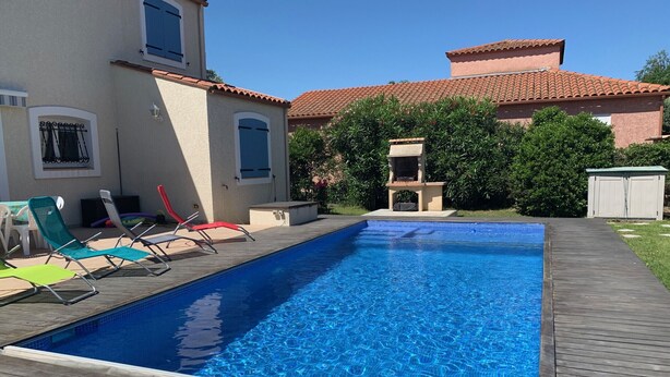 A rectangular swimming pool with a wooden deck, surrounded by a house with a tiled roof and a small barbecue area. - Villa with private pool, AC, 3 bdr, garden, parking and WIFI in Elne (Elne)