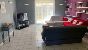 A living room with a TV, a sofa, a red couch, and a bookshelf. - Villa with private pool, AC, 3 bdr, garden, parking and WIFI in Elne (Elne)