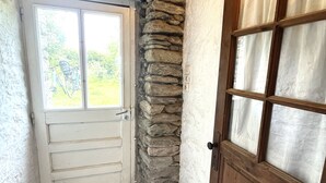 A narrow doorway with a white door and a stone wall. - Spacious house with garden in the heart of Lomener (Groix)